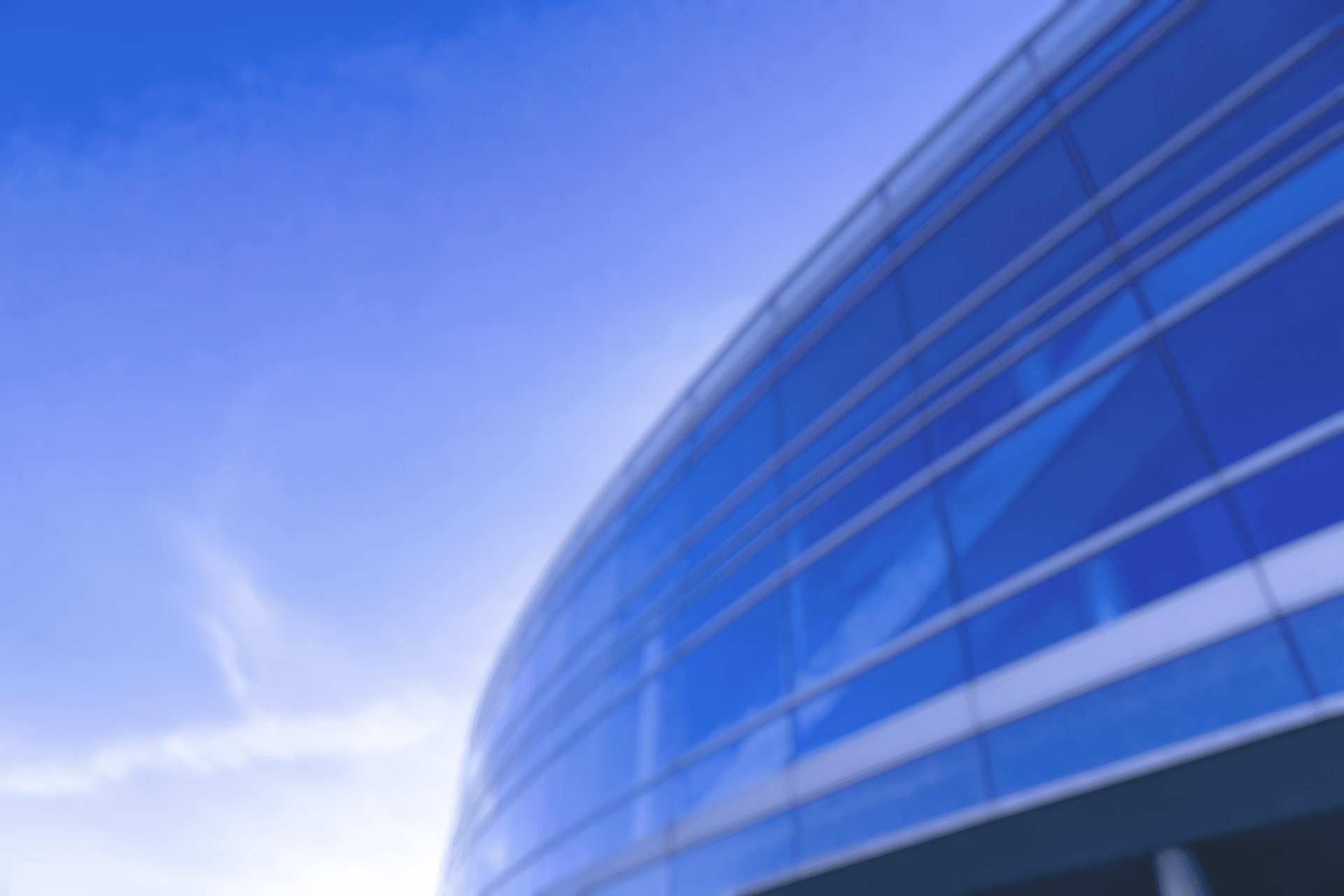 Modern Curved Glass Building with Blue Sky Reflections